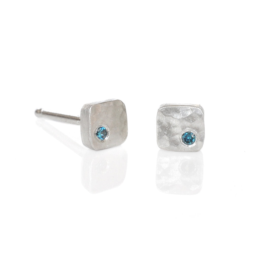 Hammered silver square studs with teal color enhanced blue diamonds. Handmade by EC Design using recycled metal and conflict-free stones.